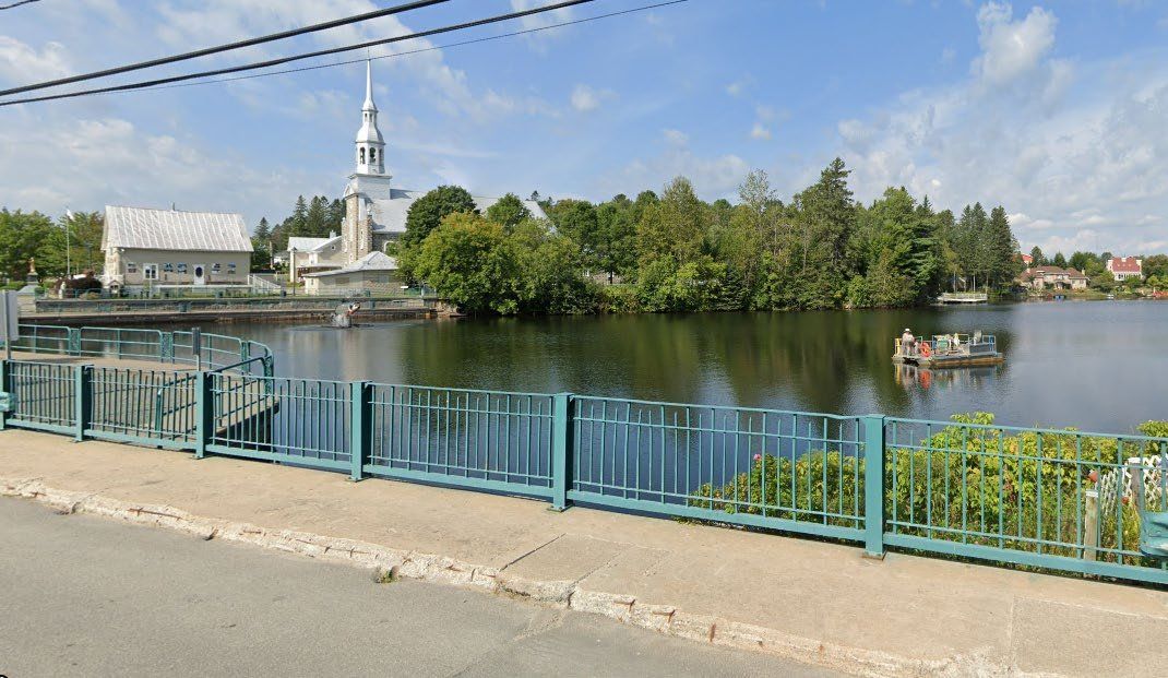 Réservoir et barrage au cœur d’un village, vus depuis la route